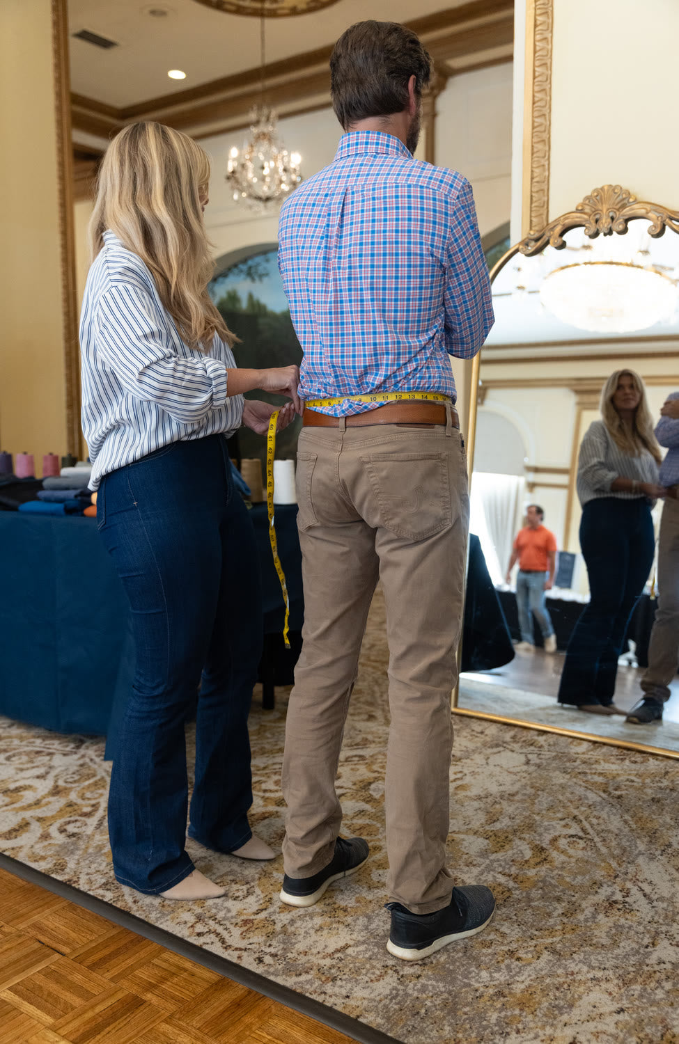 A tailor measuring a customer at a Blue Delta fitting
