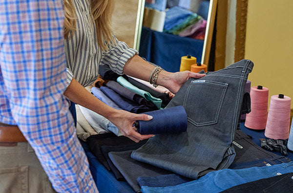 A Blue Delta Jeans specialist conducting a bespoke fitting for a client at a luxury corporate gifting event.