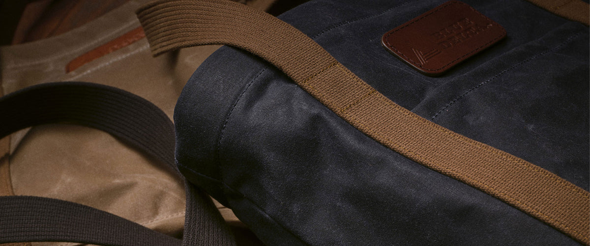 Navy and tan wet-waxed canvas bags with leather patches