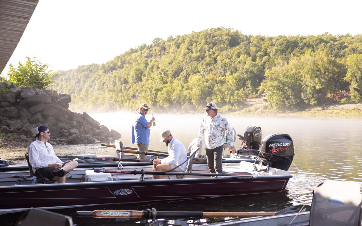 Anglers on bass boats on a misty river at sunrise