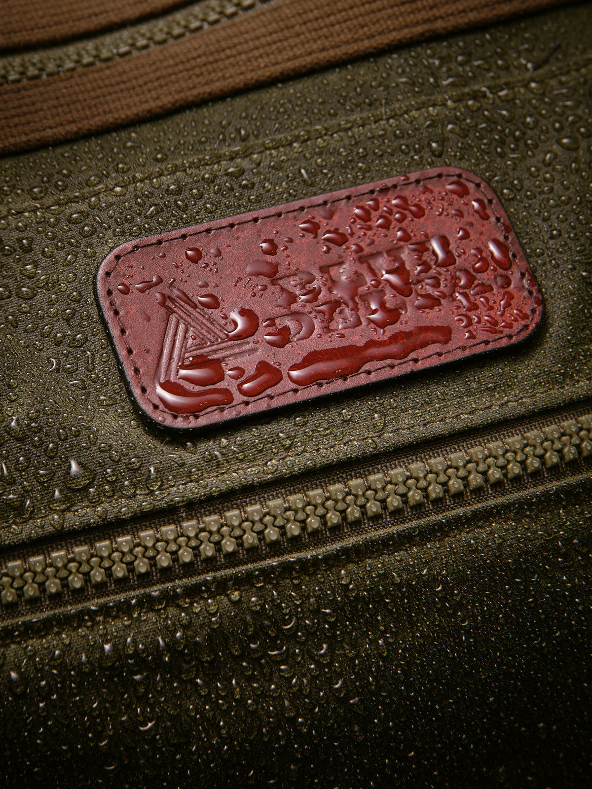 Waxed Canvas Duffle in green: leather patch with water beading