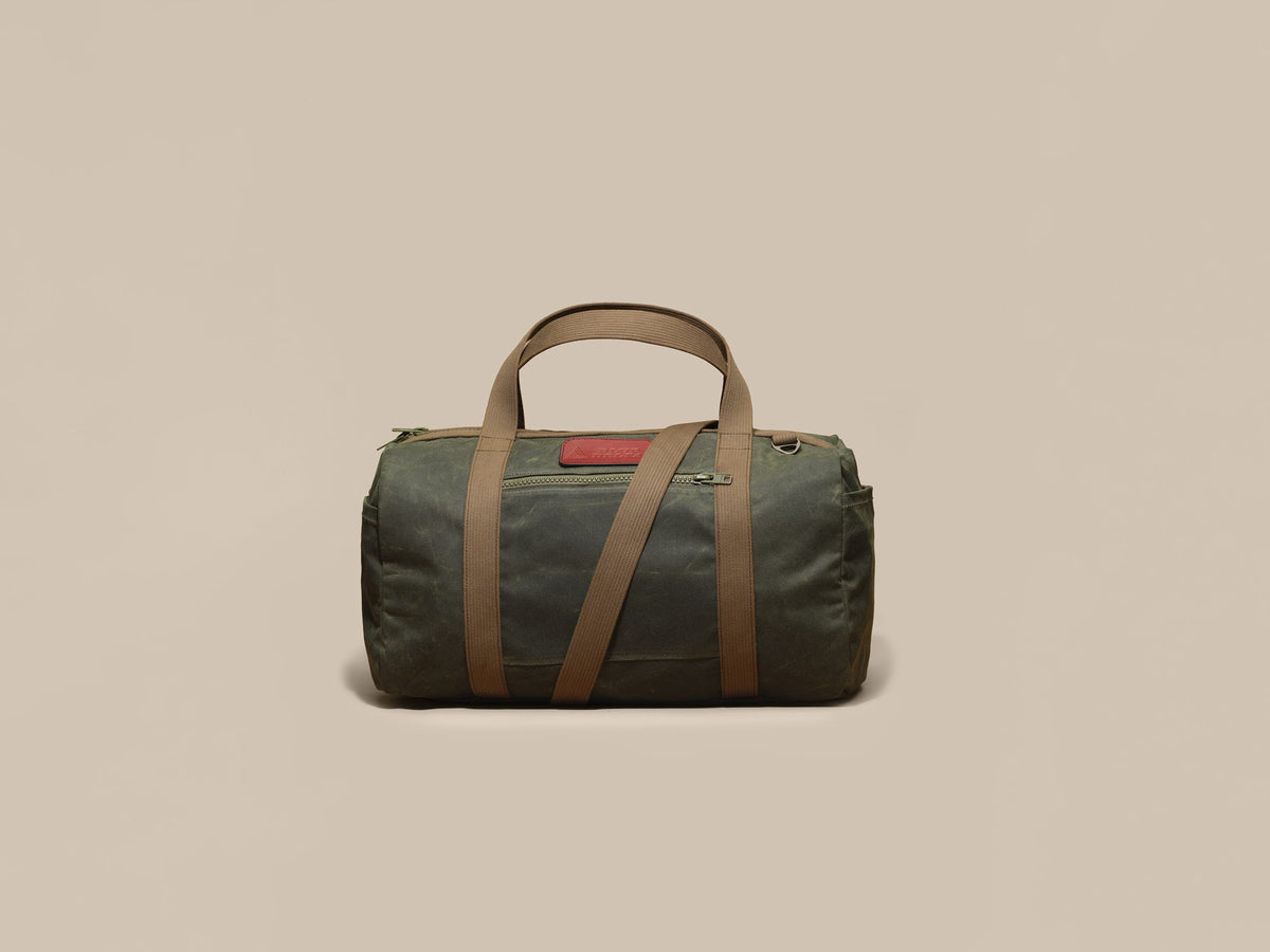 Waxed Canvas Duffle in green waxed canvas with green webbing and a Chestnut leather patch, front
