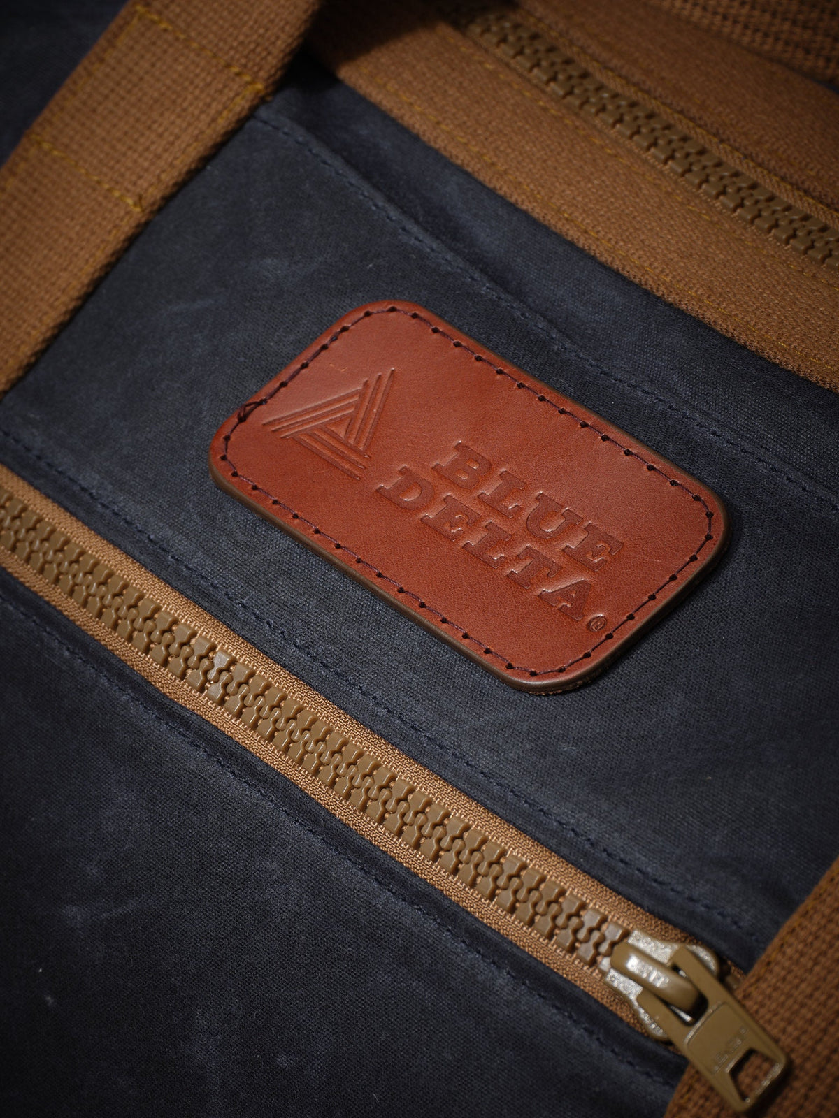 Waxed Canvas Duffle in navy: leather logo patch and front zipper pocket