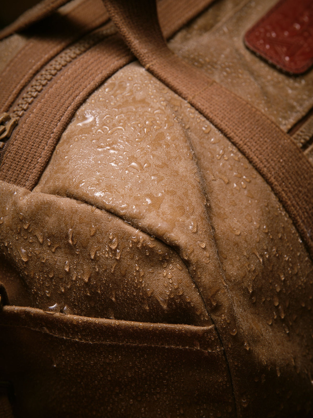 Waxed Canvas Duffle in tan: water beading on the waxed canvas