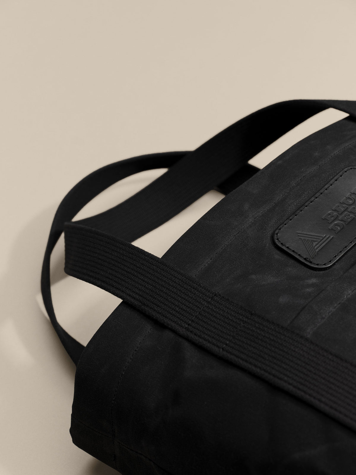 Waxed Canvas Tote in black: leather patch and webbing handles