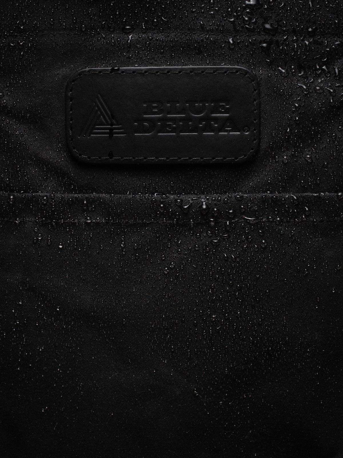 Waxed Canvas Tote in black: water beading around the leather patch