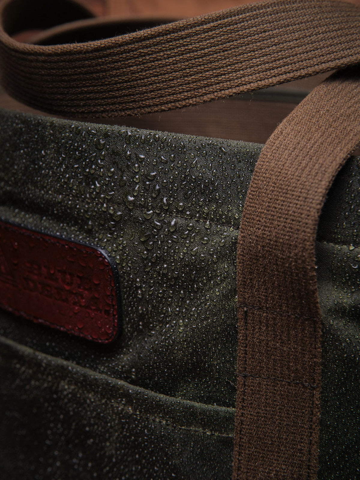 Waxed Canvas Tote in green: water beading on the canvas by the handle