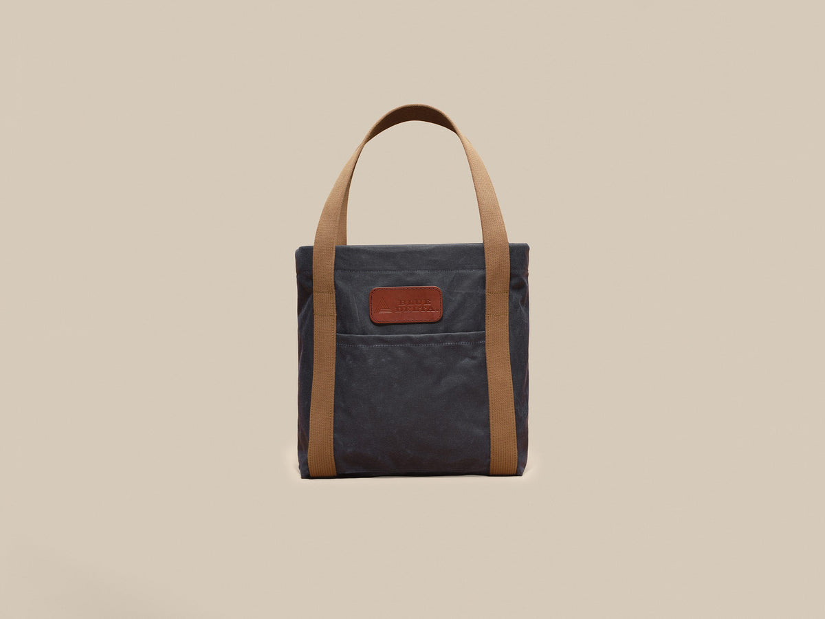 Waxed Canvas Tote in navy waxed canvas with tan webbing and a Rich Brown leather patch, patch side
