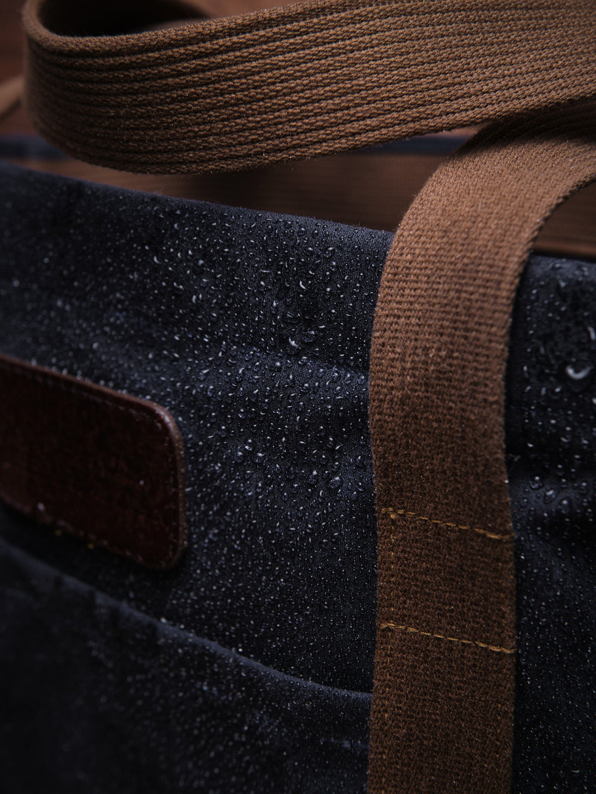 Waxed Canvas Tote in navy: water beading on the canvas by the handle