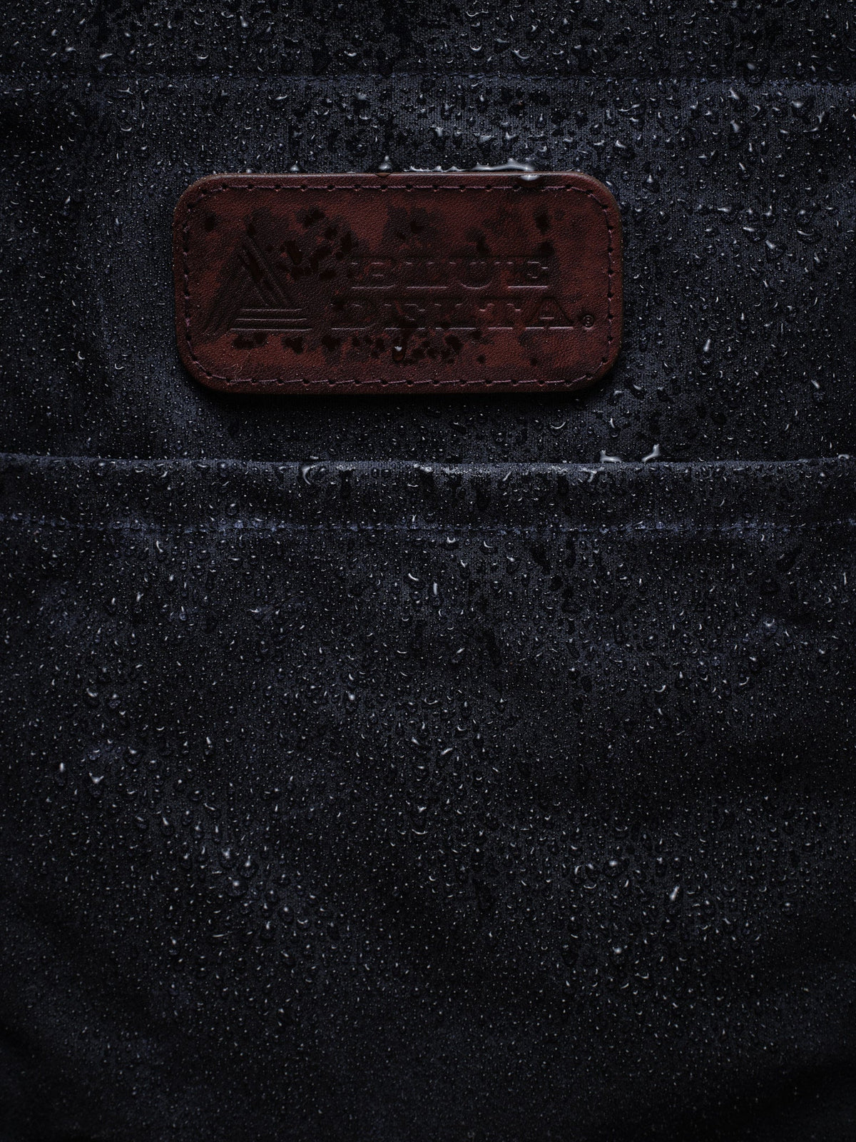 Waxed Canvas Tote in navy: water beading around the leather patch