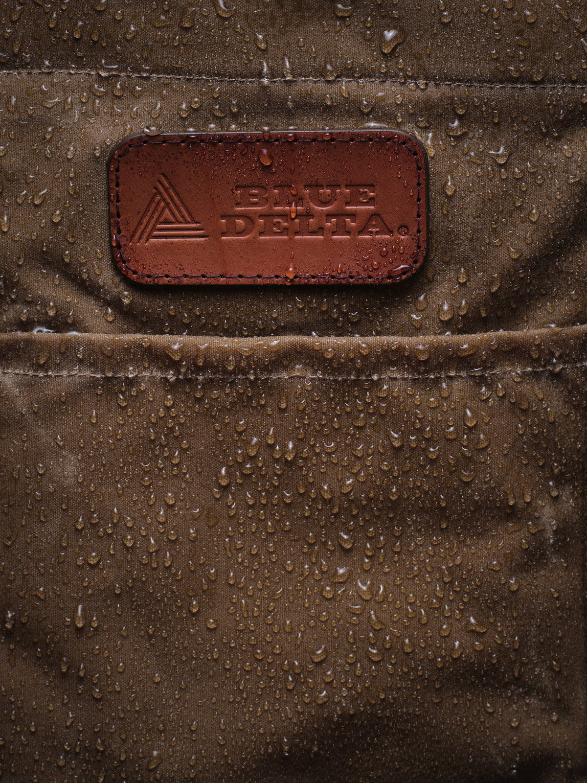 Waxed Canvas Tote in tan: water beading around the leather patch