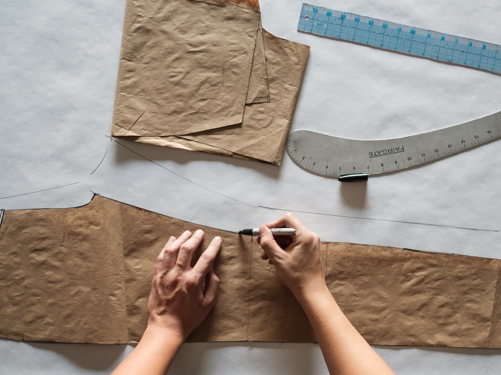 A pattern maker tracing a new paper pattern
