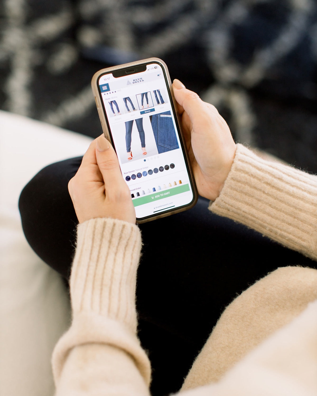 Hands holding a phone showing a Blue Delta jeans page